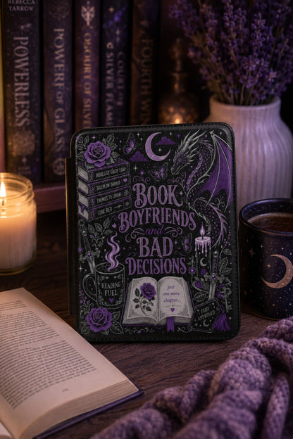 Kindle case styled with a lit taper candle, stacked books, and a steaming mug for a cozy gift flat lay