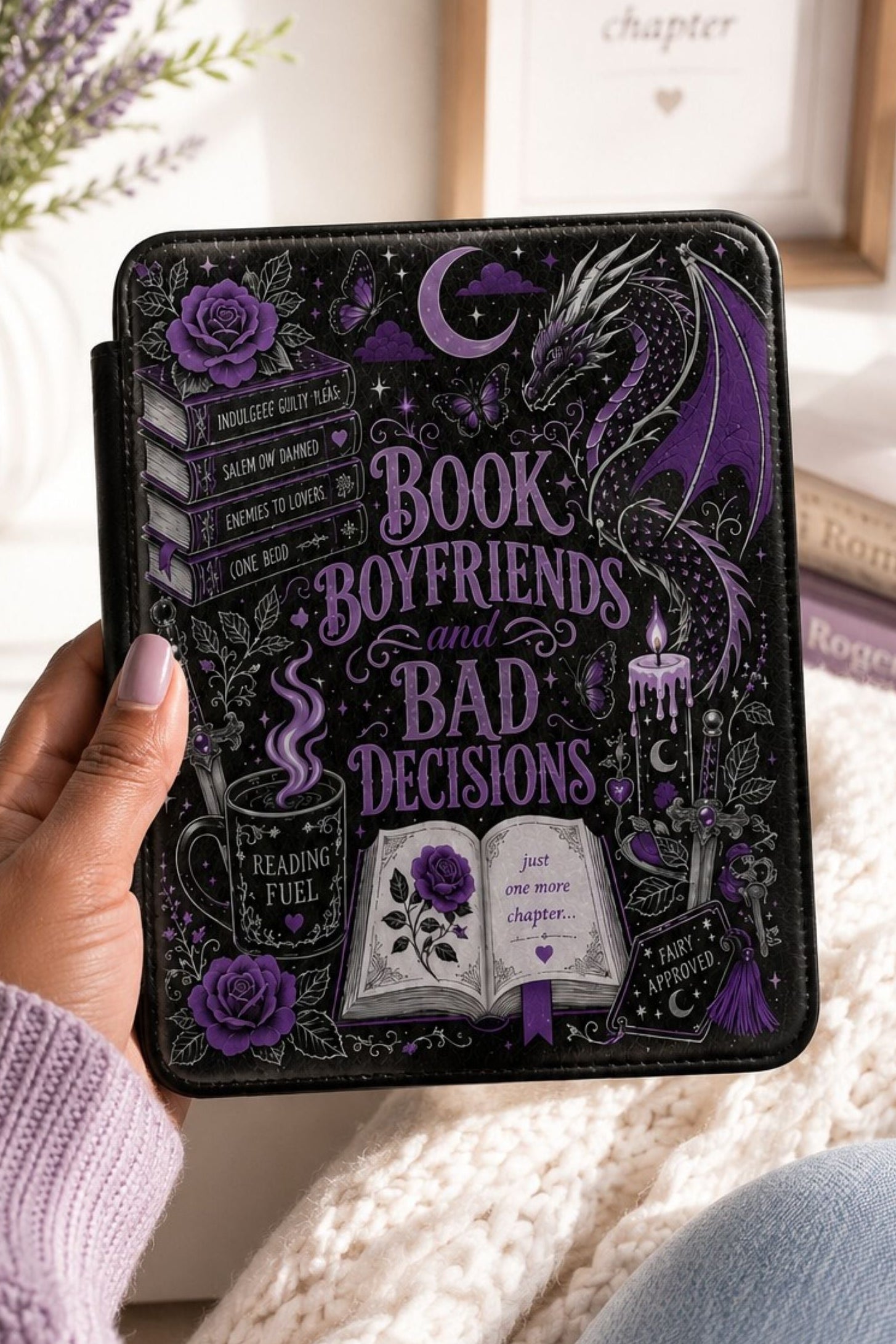 Hand holding open Kindle case, satin-finish dragon art catching warm bedside lamp light