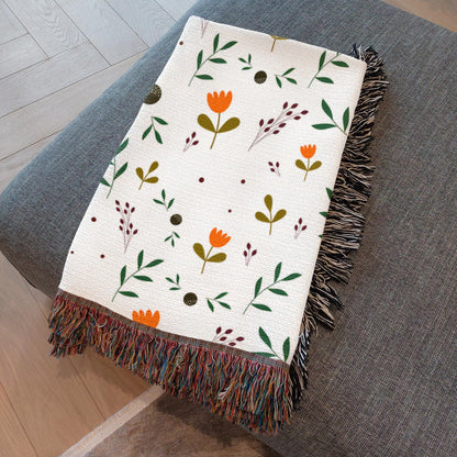 Folded boho throw blanket showcasing warm earth tones and botanical print